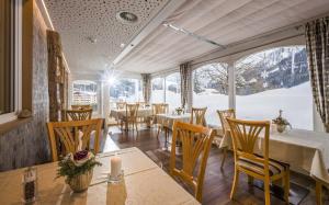 un comedor con mesas y sillas y una gran ventana en Liebes Caroline 4-Sterne-Hotel en Pertisau