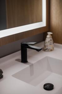 lavabo con grifo negro y espejo en BungaLove en Benalmádena