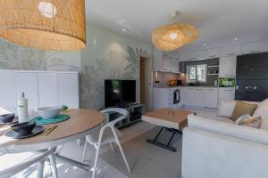uma cozinha e sala de estar com uma mesa e um sofá em BungaLove em Benalmádena