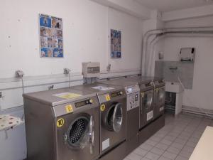 una lavandería con tres lavadoras. en Studio Brides-les-Bains, 1 pièce, 4 personnes - FR-1-512-247, en Brides-les-Bains