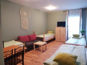 ein Wohnzimmer mit 2 Betten und einem Sofa in der Unterkunft Hostel Gliwice Centrum in Gliwice