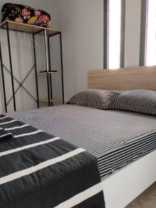 a bed with a black and white comforter in a room at The mulberry apartment in Korfos