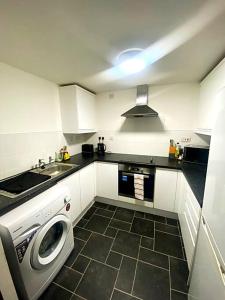 Nottingham city view apartment في نوتينغهام: مطبخ مع غسالة ومغسلة