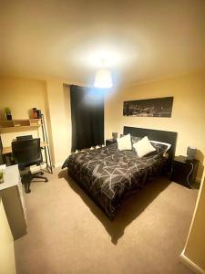 a bedroom with a bed and a desk and a lamp at Nottingham city view apartment in Nottingham