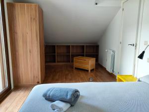 an attic bedroom with a bed and a wooden cabinet at Casa turística a Ardiña in Caldas de Reis