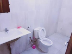 a bathroom with a white toilet and a sink at Appartement trois chambres salon in Saint-Louis