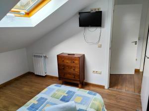 a bedroom with a bed and a tv on the wall at Casa turística a Ardiña in Caldas de Reis
