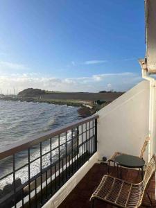 a balcony with two chairs and a view of the ocean at Relax with spectacular views and Hot Tub in Kircubbin