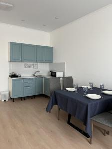 a dining room with a table and a kitchen at Lake View in Borovoye