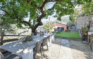 a table and chairs in a garden with a tree at Nice Home In Recco With House Sea View in Recco +44 photos