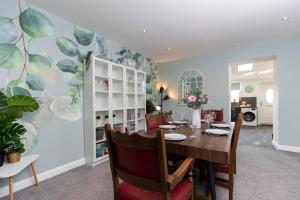 a dining room with a table and chairs and a room with a kitchen at Auckland View - a comfy & spacious 4bed with views in Coundon