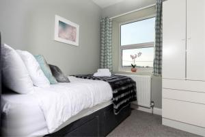 a bedroom with a large bed with a window at Auckland View - a comfy & spacious 4bed with views in Coundon