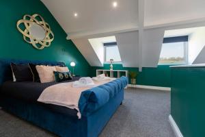 a bedroom with a blue bed and green walls at Auckland View - a comfy & spacious 4bed with views in Coundon