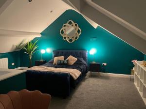 a bedroom with a green accent wall and a bed at Auckland View - a comfy & spacious 4bed with views in Coundon