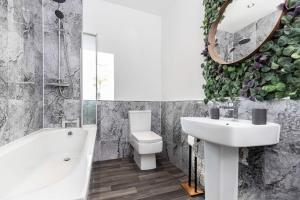 a bathroom with a sink toilet and a mirror at Auckland View - a comfy & spacious 4bed with views in Coundon +19 photos