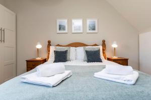 a bedroom with a large bed with two white towels at Auckland View - a comfy & spacious 4bed with views in Coundon