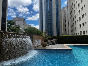 a swimming pool with a water fountain in a city at Flat - Al Santos - Prox Av Paulista in Sao Paulo