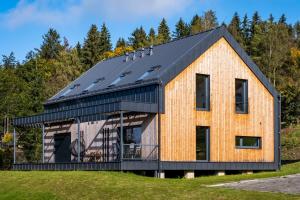 una casa con paneles solares en el techo en Holiday House U Hájenky 7L Lipno Home, en Lipno nad Vltavou