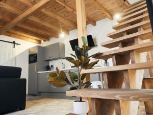 une cuisine avec des escaliers en bois et une table avec une plante dans l'établissement La Encantada 2, à Elche de la Sierra