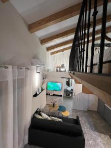 een woonkamer met een zwarte bank en een tv bij La Encantada 2 in Elche de la Sierra