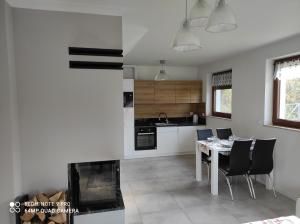 a kitchen and dining room with a table and chairs at Domki Pod Brzyzkiem in Ochotnica Dolna