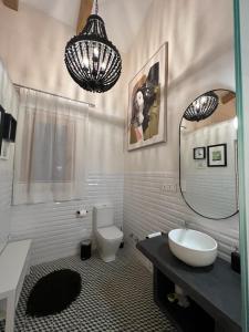 een badkamer met een wastafel, een toilet en een spiegel bij La Encantada 2 in Elche de la Sierra