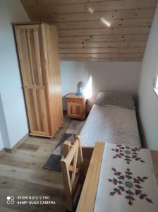 - une chambre avec 2 lits et une porte en bois dans l'établissement Domki Pod Brzyzkiem, à Ochotnica Dolna