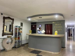 un hombre sentado en un mostrador en un baño en Hotel Caldas Plaza, en Caldas