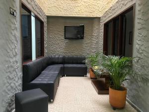 sala de estar con sofá y TV en la pared en Hotel Caldas Plaza, en Caldas