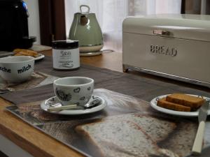 uma mesa com sanduíches e chávenas de café e pão em “Come A Casa” Ferrara em Ferrara