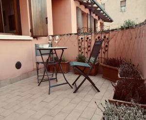 een patio met een tafel en een stoel op een balkon bij “Come A Casa” Ferrara in Ferrara