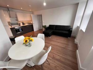 a living room with a white table and white chairs at 2 Bed Apt, 20 mins from London, central romford in London