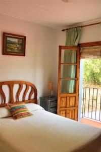 1 dormitorio con cama y ventana en HOSTAL MONCADA, en Gaucín