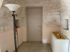 una camera con una lampada da pavimento e un muro in pietra di La Valle dei Trulli Relais a Martina Franca Altre 57 foto