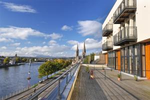 a boardwalk next to a river with a building at Highland Apartments by Mansley in Inverness
