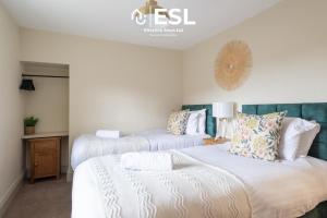 2 camas en una habitación con paredes blancas en Free Parking - Shrewsbury Square - Central 2 Bedroom Top Floor Apartment en Shrewsbury
