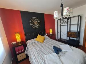 タピア・デ・カサリエゴにあるapartamento Titaの赤い壁のベッドルーム1室(大型ベッド1台付)
