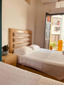a bedroom with two beds and a window at Hostal 1545 in Ríohacha