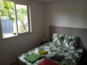 - une chambre avec un lit et une fenêtre dans l'établissement Meublé le manguier, à Saint-Pierre