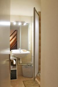 ein Bad mit einem Waschbecken und einem Spiegel in der Unterkunft Duplex sur le lac Les Angles 7 personnes in Les Angles