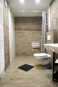 a bathroom with a white toilet and a sink at Vila Lada in Dedinky