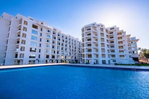 a swimming pool in front of two large buildings at The Comfortable palace in Hurghada +23 photos