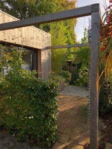 una puerta de cristal a un jardín con un arbusto en Jeltje, en Wildervank