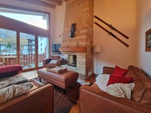 sala de estar con 2 sofás y chimenea en Haus Serac en Saas-Fee