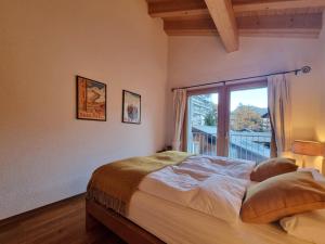 a bedroom with a bed and a large window at Haus Serac in Saas-Fee