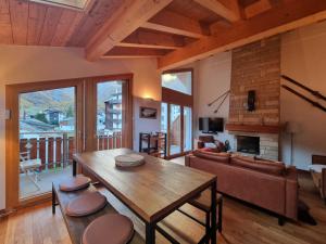 a living room with a wooden table and a fireplace at Haus Serac in Saas-Fee