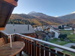 a balcony with a view of a town and mountains at Haus Serac in Saas-Fee