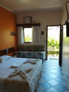 ein Hotelzimmer mit 2 Betten und einem Sofa in der Unterkunft Pousada Maui in Ubatuba