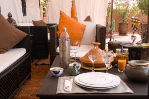 a table with plates and wine glasses on a patio at Riad Mariana in Marrakesh