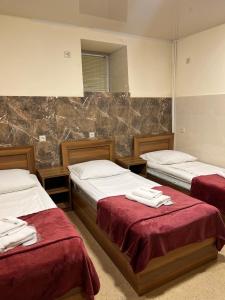 a bedroom with two beds with red sheets and a mirror at Adamyan 11 hotel in Yerevan
